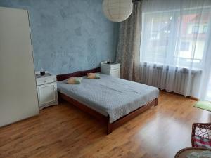 um quarto com uma cama e uma grande janela em Mieszkanie u Zofii - Krościenko n.D em Krościenko