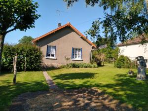 une maison avec une statue en face d'une cour dans l'établissement Gîte La Maison de LEA, à Saint-Agnant-de-Versillat