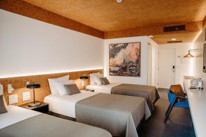 a hotel room with two beds and a table at Canadiano Urban Nature Hotel in Ponta Delgada +61 photos