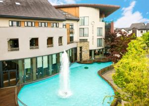 une fontaine dans une piscine en face d'un bâtiment dans l'établissement Osprey Hotel, à Naas