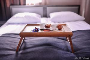 ein Tablett mit Kaffeetassen und Donuts auf dem Bett in der Unterkunft Apart Hotel Sayat-Nova in Wanadsor