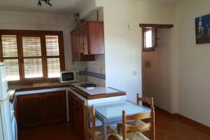 una pequeña cocina con mesa y microondas en Apartamento Rústico VILLA MOCA Bubión, en Bubión