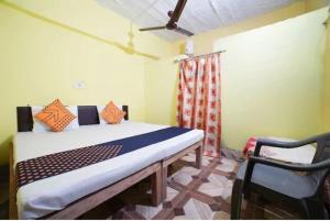um quarto com uma cama e duas cadeiras em Vamoose Srishti - Chamoli em Gopeshwar
