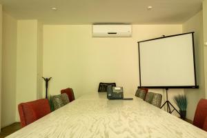 una sala de conferencias con una mesa con sillas y una pizarra en Hotel Nak'An Secreto Maya, en Comitán de Domínguez