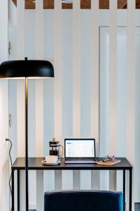 a desk with a laptop and a lamp on it at Canadiano Urban Nature Hotel in Ponta Delgada