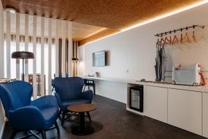 a living room with two blue chairs and a table at Canadiano Urban Nature Hotel in Ponta Delgada