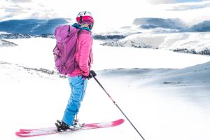 una mujer está parada en los esquís en la nieve en Storestølen Fjellhotell en Hovet