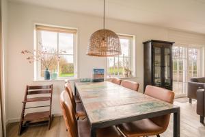 Un comedor con mesa y sillas de madera. en Annabella 11, en De Koog