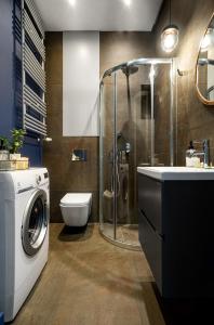 a bathroom with a washing machine and a toilet at TS Boutique Apartments in Szczecin