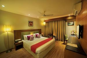 een hotelkamer met een bed en een televisie bij Jk Park Residency Perambra in Mennānyam