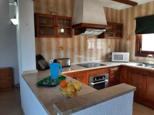 una cocina con un bol de fruta en una barra en Villa Limon - Tropical Oasis with Private Pool, en Jávea