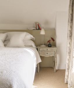 a bedroom with a bed and a table with a lamp at Penally Abbey Country House Hotel and Restaurant in Tenby