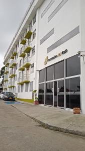 een groot wit gebouw met een auto ervoor geparkeerd bij Apartamento turístico Guaduales del Cafe in Montenegro