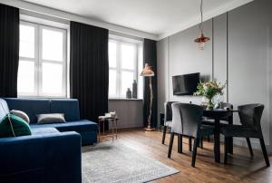 シュチェチンにあるTS Boutique Apartmentsのリビングルーム(青いソファ、テーブル付)