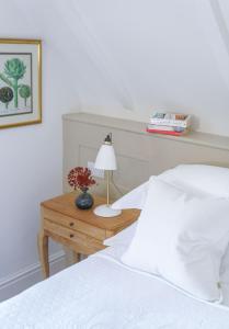 a bedroom with a bed and a table with a lamp at Penally Abbey Country House Hotel and Restaurant in Tenby