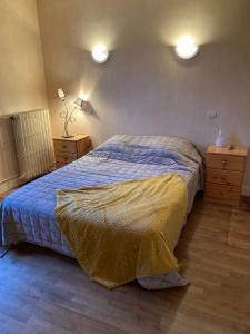 a bedroom with a bed with a blue comforter at MON DADA in Granville