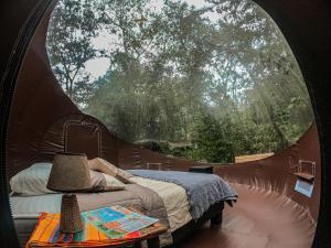 ein Schlafzimmer mit einem Bett in einem runden Fenster in der Unterkunft Mindo GlamBird Glamping & Lodge in Mindo