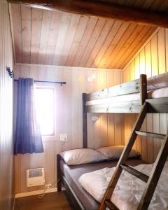 a bunk bed room with two bunk beds in a cabin at Groven Camping & Hyttegrend in Åmot