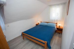 a bedroom with a blue bed and a window at Apartment Matejuška in Split