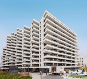a large white apartment building with balconies at Millennium La Tour in Warsaw