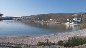 a body of water with houses on the shore at Family house by the seaside of Karavostasis in Karavostasi
