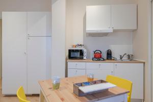 a kitchen with a wooden table with yellow chairs at Via Goletta Home in Sciacca