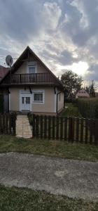 a house with a wooden fence in front of it at Kotnyek nyaraló in Balatonkeresztúr