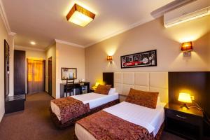ロストフ・ナ・ドヌにあるVilla Diegoのベッド2台とバスルームが備わるホテルルームです。