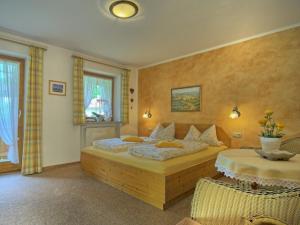 a bedroom with a large bed and two chairs at Landhaus Eschenbach in Schönau am Königssee