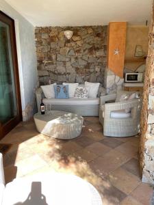 un soggiorno con divano e parete in pietra di Charming Holiday Home a Chia