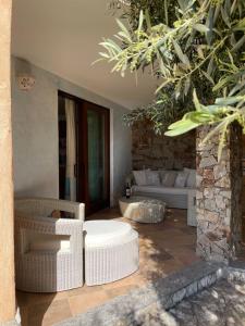 sala de estar con muebles de mimbre y pared de piedra. en Charming Holiday Home en Chia