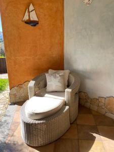 a wicker chair with a pillow on a patio at Charming Holiday Home in Chia