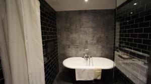 a bathroom with a white sink and black tiles at 朵兒dor韓國汗蒸幕 동대문점 商務旅店 in Taipei