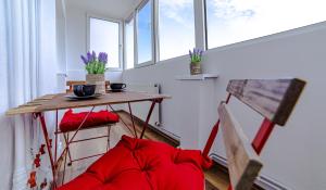 uma pequena mesa e cadeiras num quarto com janelas em Apartament Garii em Braşov