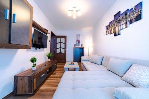 uma sala de estar com um sofá e uma televisão em Apartament Garii em Braşov