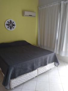 a bedroom with a bed with a black comforter at condominio moradas de guarajuba in Guarajuba