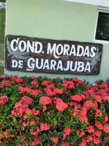 a sign for a garden with red flowers at condominio moradas de guarajuba in Guarajuba
