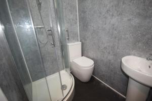 a bathroom with a toilet and a shower and a sink at The Retreat in Blackpool