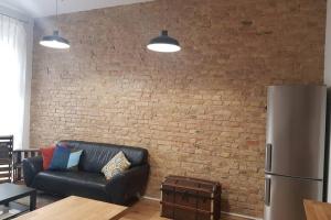 a living room with a black couch and a brick wall at Tempelhoferfeld in Berlin