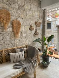 a room with a couch and a stone wall at Aliko Hotel in Alaçatı