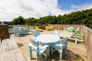 a patio with a table and chairs on a wooden deck at The Wright Place in Kitty Hawk