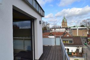 a balcony of a building with a view of a church at Loft Apartments Pulheim in Pulheim