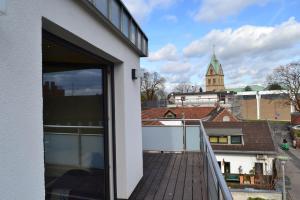 einen Balkon eines Gebäudes mit Blick auf eine Kirche in der Unterkunft Loft Apartments Pulheim in Pulheim