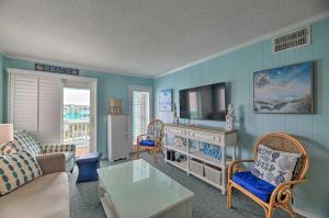 a living room with a couch and a tv at Beachfront Condo with Boardwalk and Pool Access! in Atlantic Beach