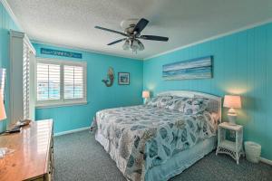 a bedroom with blue walls and a bed with a ceiling fan at Beachfront Condo with Boardwalk and Pool Access! in Atlantic Beach +24 photos