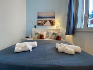 1 dormitorio con 1 cama grande con almohadas blancas en Venti di Brucoli, en Brucoli