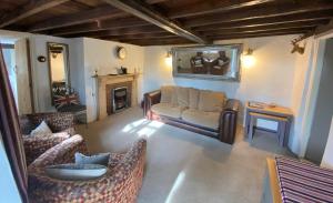 a living room with a couch and a fireplace at Thatch Cottage, East Boldre nr Beaulieu and Lymington in Brockenhurst