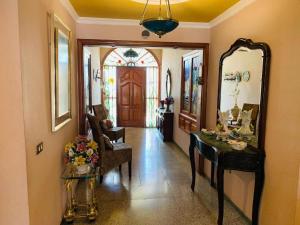 un couloir avec un miroir, une table et une chaise dans l'établissement Vivienda Vacacional FLORATERE, à Arona