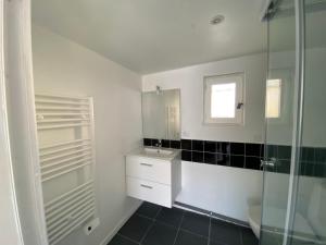 a bathroom with a sink and a glass shower at Un coin en Provence in Villeneuve