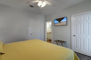 a bedroom with a yellow bed and a ceiling fan at I am So Swamped in Port Aransas